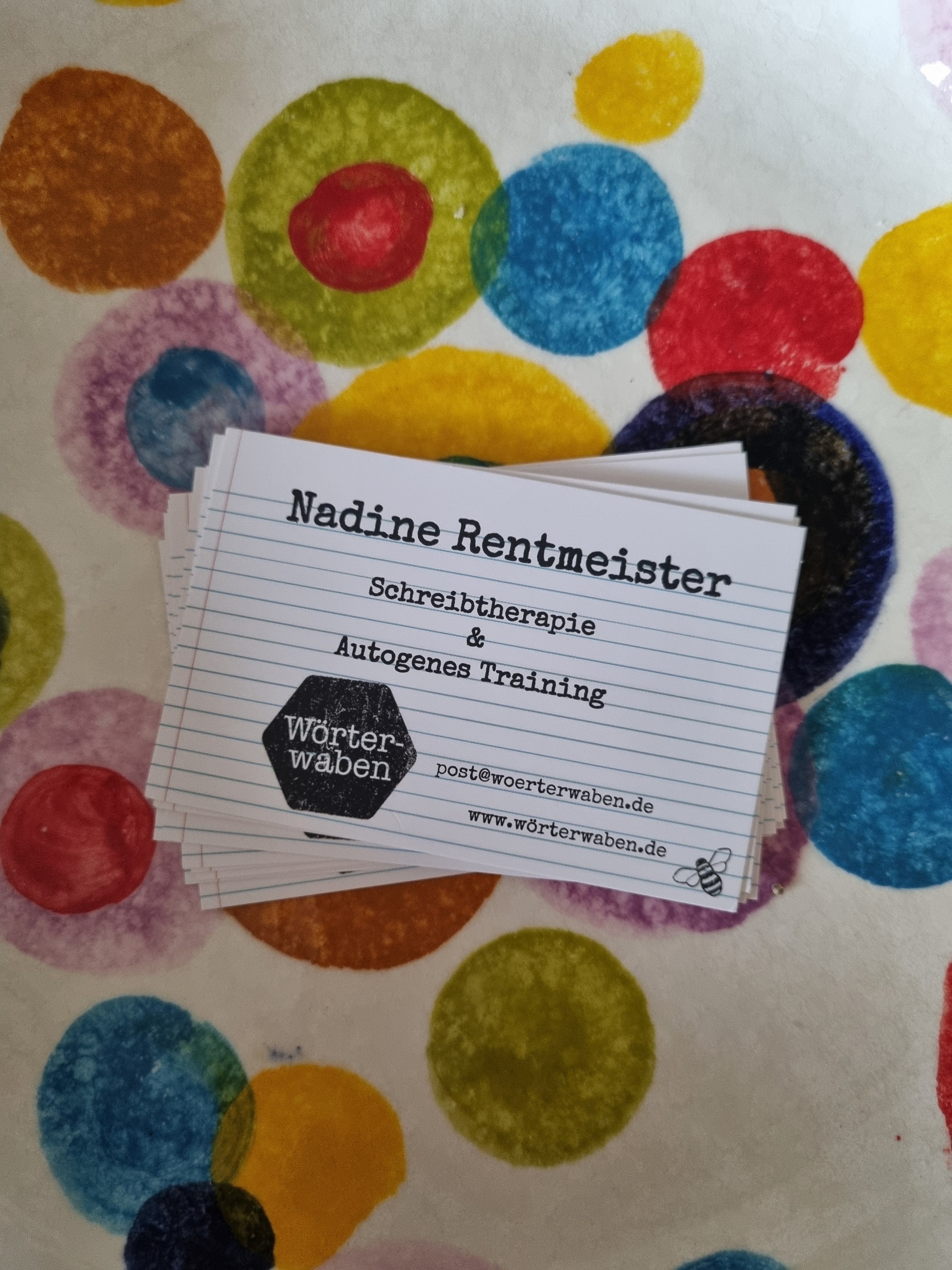 Visitenkarten von Nadine Rentmeister auf buntem Punktmuster – mit Hinweis auf Schreibtherapie & Autogenes Training.